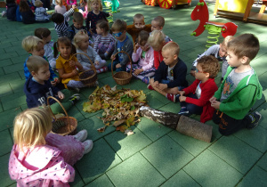 Dzieci z uzbieranych liści oraz kory przygotowanej przez panie ułożyły „Leżące drzewo”.